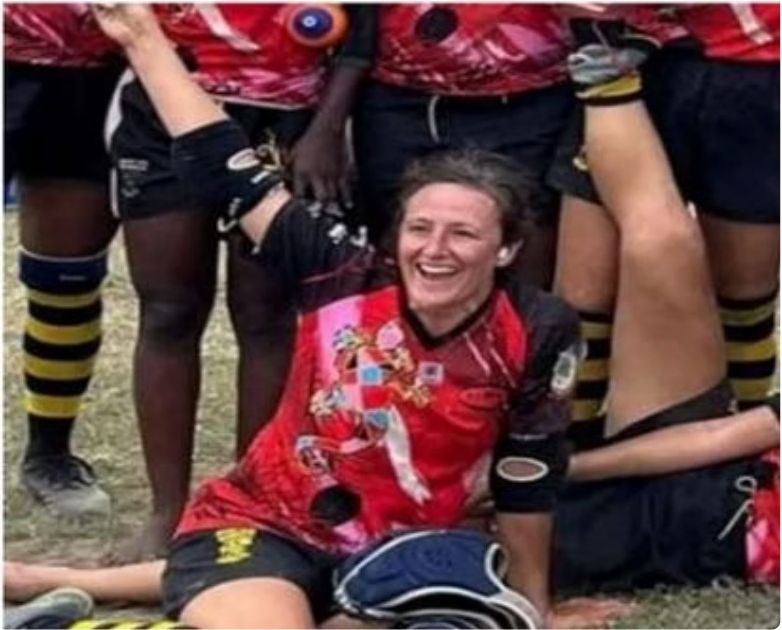 Nadine souriante en maillot de rugby, entourée de coéquipières